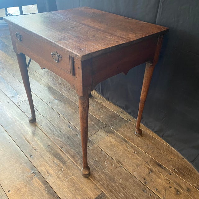 Antique English Georgian oak side table dating to the late 18th century featuring a beautifully aged plank top with a...