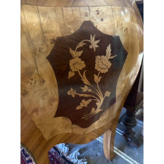 An exquisite bombé-form commode in the opulent Rococo revival of the Louis XV style, richly veneered in golden burled wood...