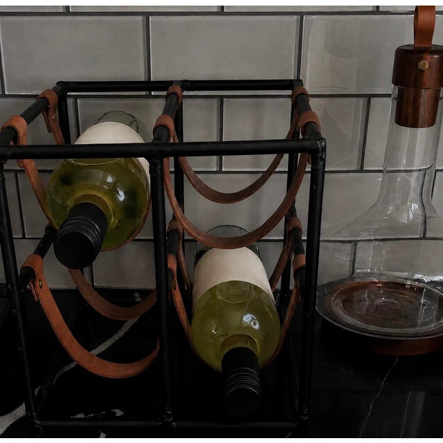 Arthur Umanoff wine rack with blackened iron framework and saddle leather supports, embodying the understated...