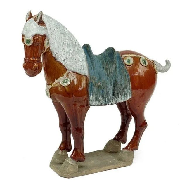 The horse is shown standing on a slab base with ears pricked and head turned slightly to the right and is covered with a...