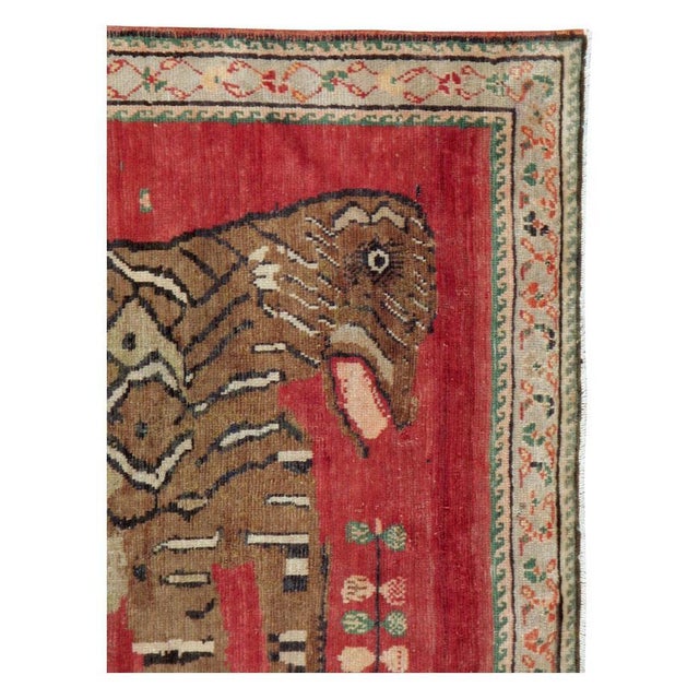 A vintage Caucasian Karabagh accent rug handmade during the mid-20th century with an informally rendered pictorial...