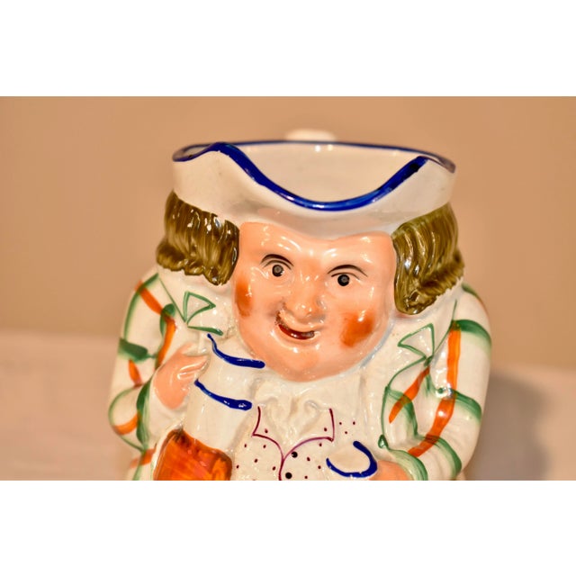 19th century ceramic Toby jug from the Staffordshire region of England. He has a lovely plaid jacket and polka dotted...