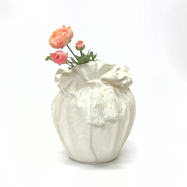 This gorgeous 1980s white vase is a plaster matte piece, featuring a ruffled detail with a rope and tassel closure....