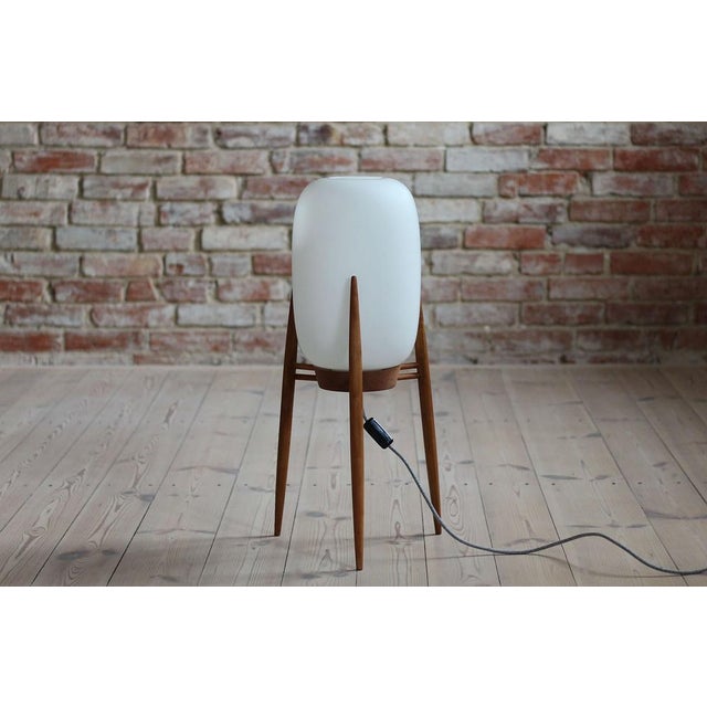 This Space Age floor lamp was produced in the 1960s in Czech Republic. It features a beautifully shaped wooden tripod base...
