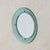 A 1960s Italian wall mirror attributed to Cristal Arte. The round central mirror is held within a pale aqua glass...