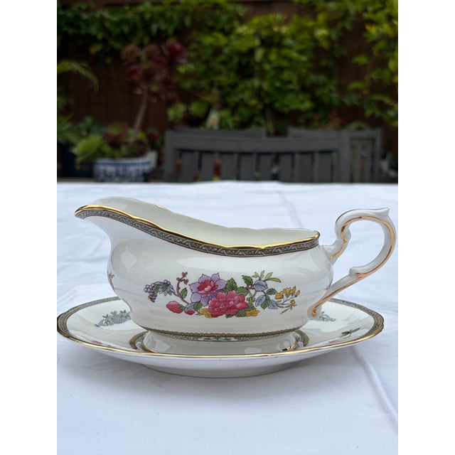A gorgeous, authentic vintage 2-piece gravy boat (sauce boat) and matching oval underplate stand set produced by Paragon...