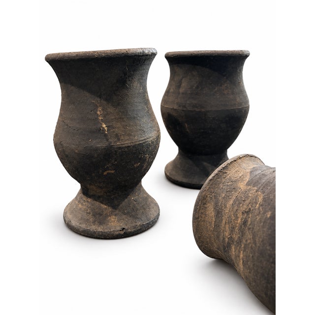 Description: A set of five hand-thrown pottery planters in earthy charcoal and warm neutral tones. Their gently flared...