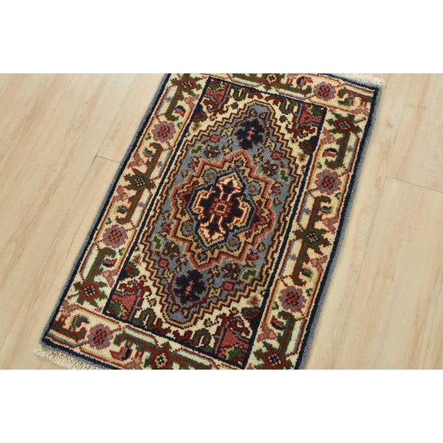 A traditional tribal Heriz rug hand-knotted with an all-wool pile on a cotton foundation. This oriental rug features a...