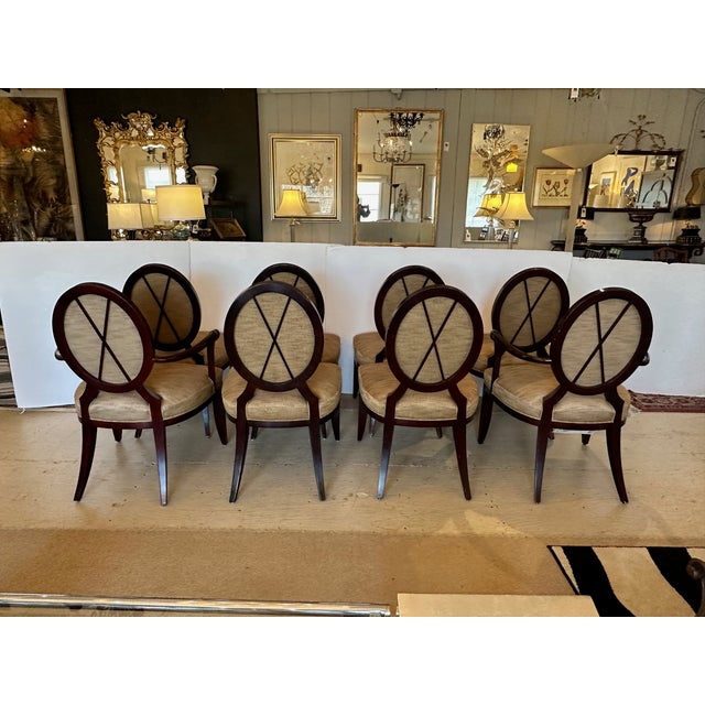 A set of 8 Barbara Barry classic "Oval X" dining chairs. Each frame is made of beech hardwood and stained mahogany with...