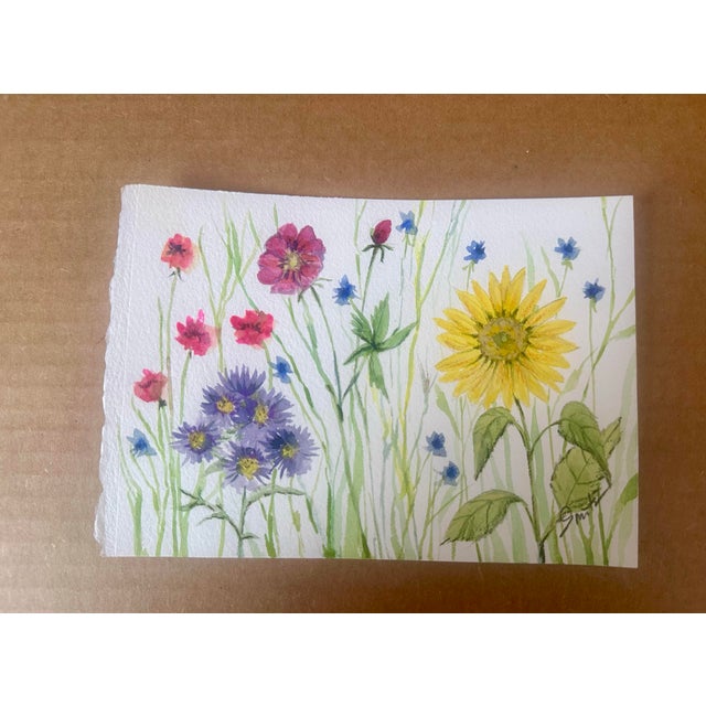 This original watercolor painting captures the quiet joy of a wild summer meadow. A radiant sunflower anchors the...