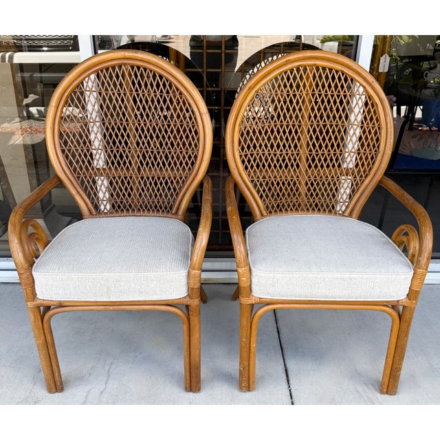 Pair of sculptural rattan peacock chairs from 1970s, featuring a distinctive scroll arm and balloon back design. Hand-...
