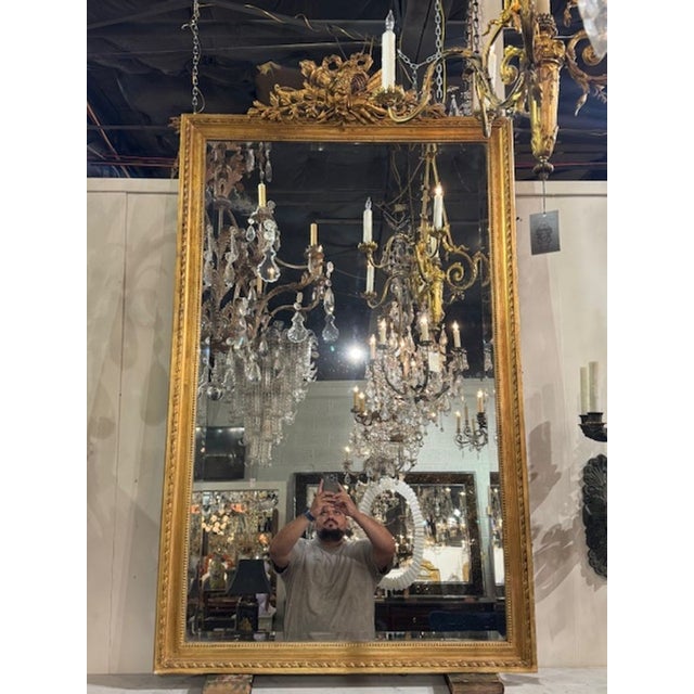The 19th Century French Louis XVI Carved and Gilded Mirror is a stunning piece that exudes elegance and sophistication....