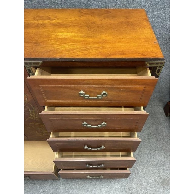 Vintage Bassett chifforobe featuring a warm wood finish, decorative Chinoiserie floral and landscape motifs, and brass-...