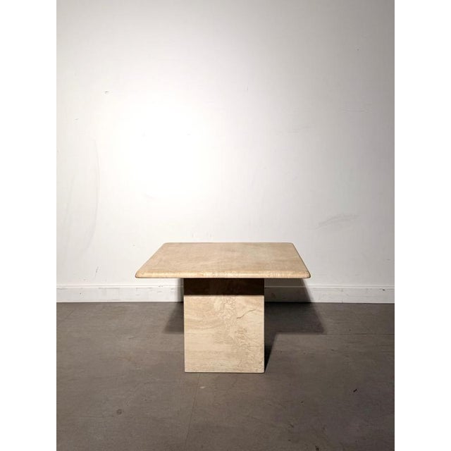 Elegant vintage travertine side table featuring a solid architectural pedestal base and a thick square top with softly...
