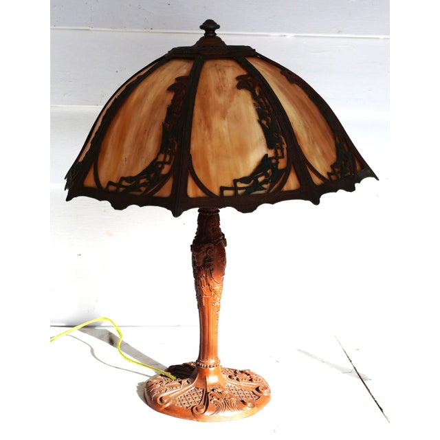 This antique Art Nouveau–era table lamp features an elegant 8-panel curved slag glass umbrella shade set within a richly...