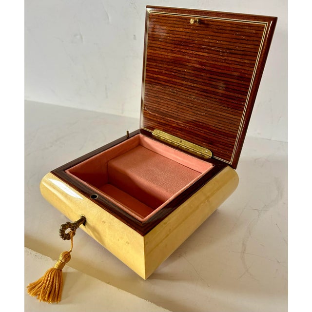 Beautiful details throughout on this lovely Reuge Italian music box. Pale yellow box topped by a floral inlaid design lid...