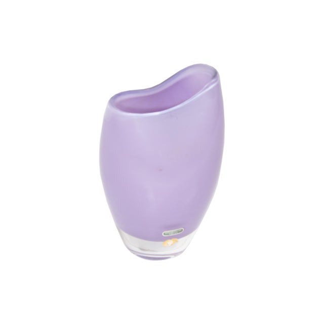 A lilac purple glass vase by Smalandshyttan Sweden. This vase comes in asymmetrical design, with one side of the top ridge...