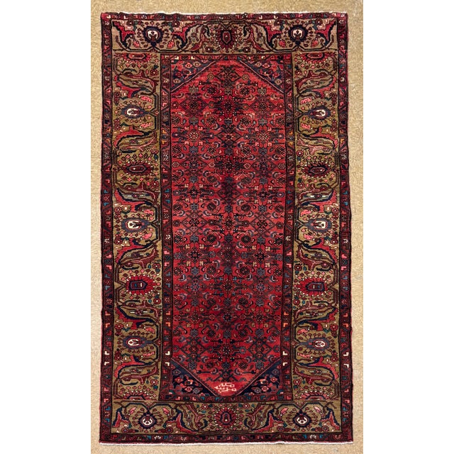 Antique hand-knotted rug from the Hamedan region of western Iran, featuring an elongated field with an allover repeating...