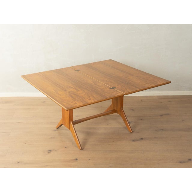 Unique dining/coffee table from the 1950s by Wilhelm Renz. Height-adjustable solid walnut frame with a fold-out walnut...