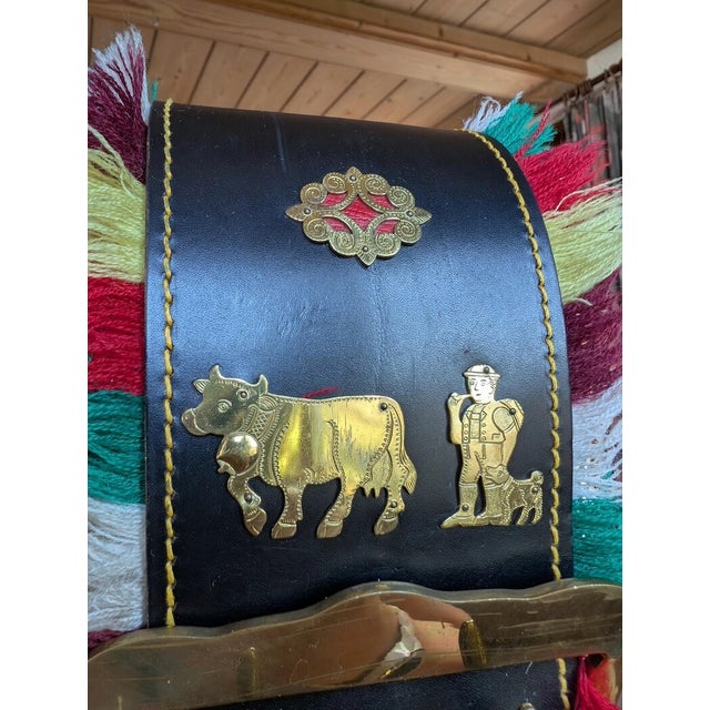 This monumental XXL Swiss cowbell is made of solid brass with an engraved inscription and features a black leather strap...