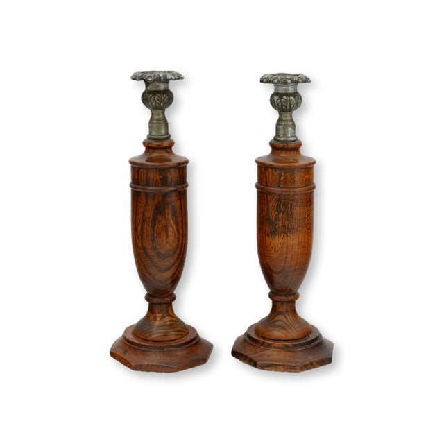Pair of early 20th century English oak candlesticks with substantial baluster forms and ornate metal candle cups. The...