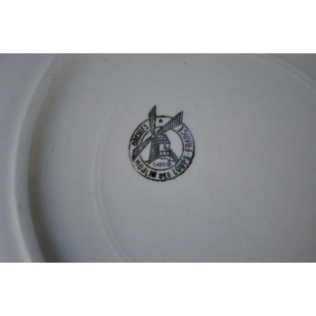 A pretty, colorful floral design adorns this antique bohemian dinnerware set, produced by the Moulin des Loups earthenware...