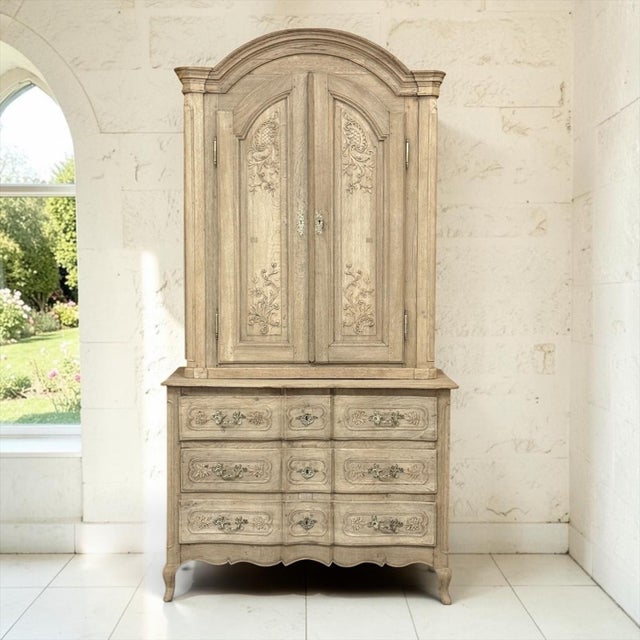 An 18th century commode a deux corps in oak, carved in the Louis XV taste of the French countryside. Hand stripped to...