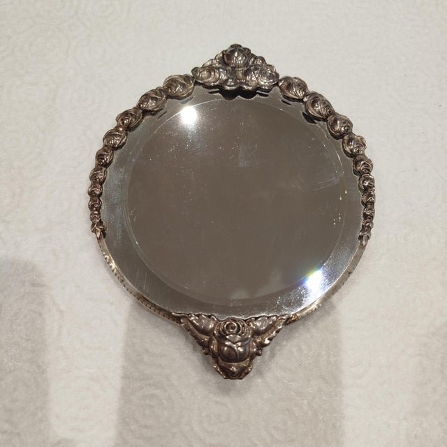 Silver mirror. 221 grams. Height: 6.3 in (16 cm) Width: 5.12 in (13 cm) Depth: 0.4 in (1 cm) This piece has an attribution...