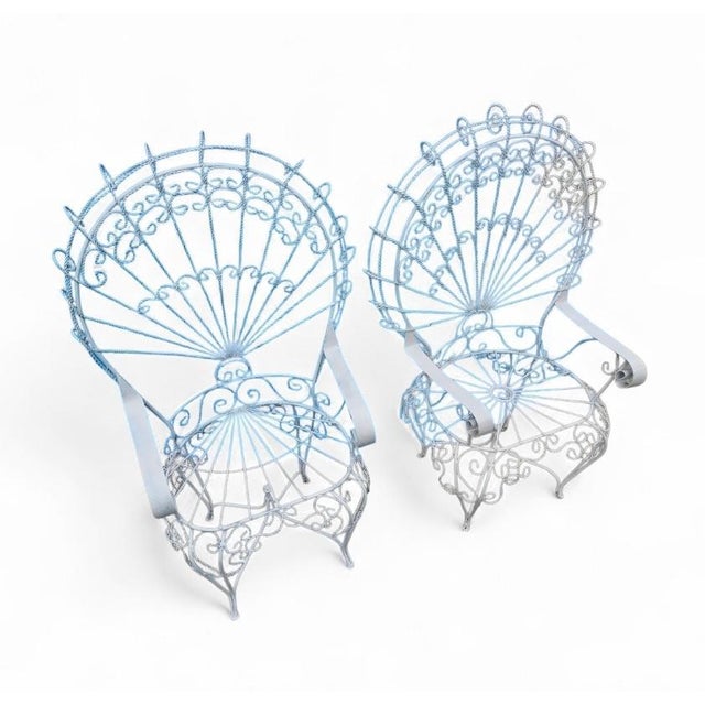 This monumental vintage set of two wrought-iron peacock chairs, in the Salterini style, features an exaggerated fan back...