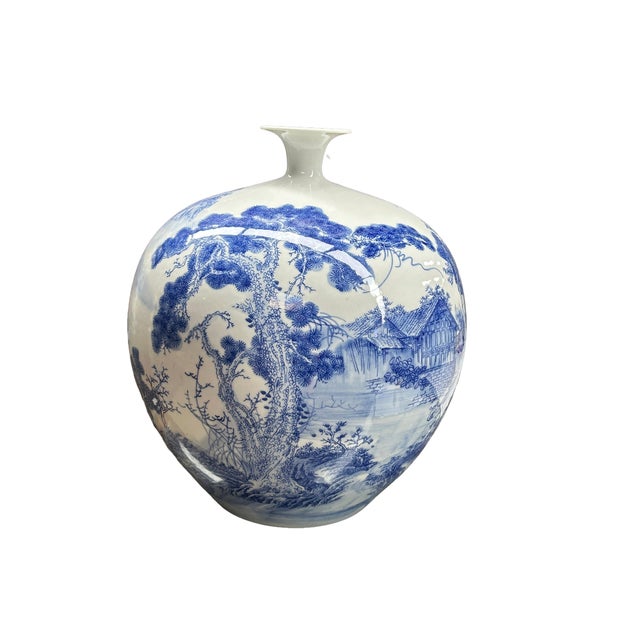 This elegant blue and white porcelain vase features a globular, full-bodied form that tapers gracefully to a narrow,...