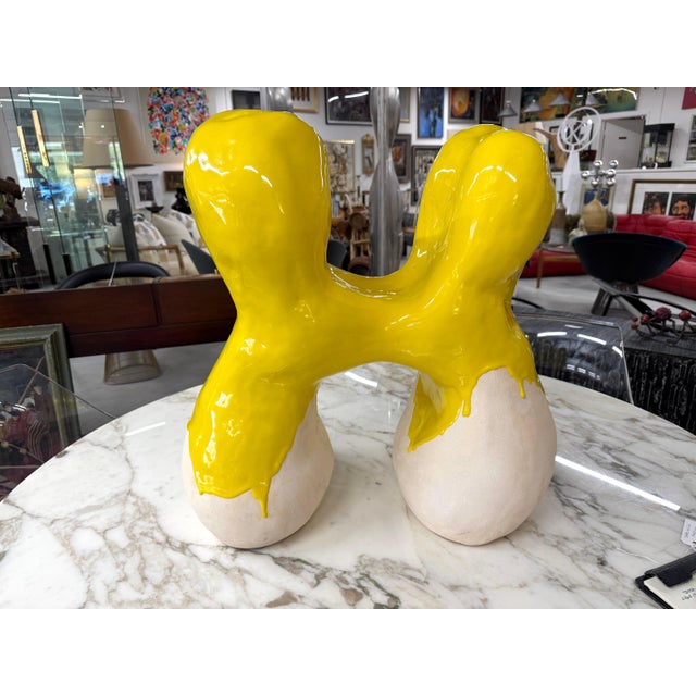 A massive stoneware abstract sculpture with a yellow partial glaze. Vaguely resembles a molar tooth or a couple embracing....