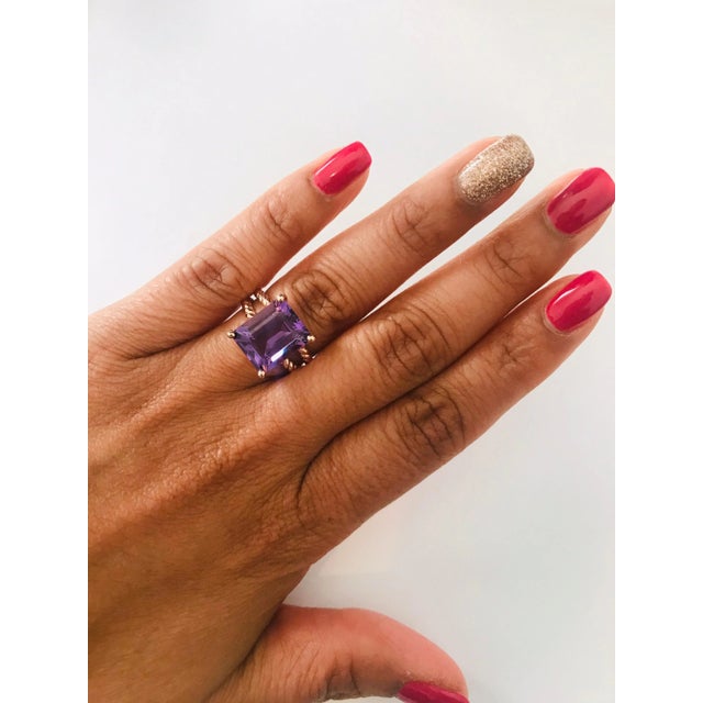 This Designer inspired ring has a bright and vivid Emerald Cut Amethyst in the center that weighs 5.51 carats. The setting...