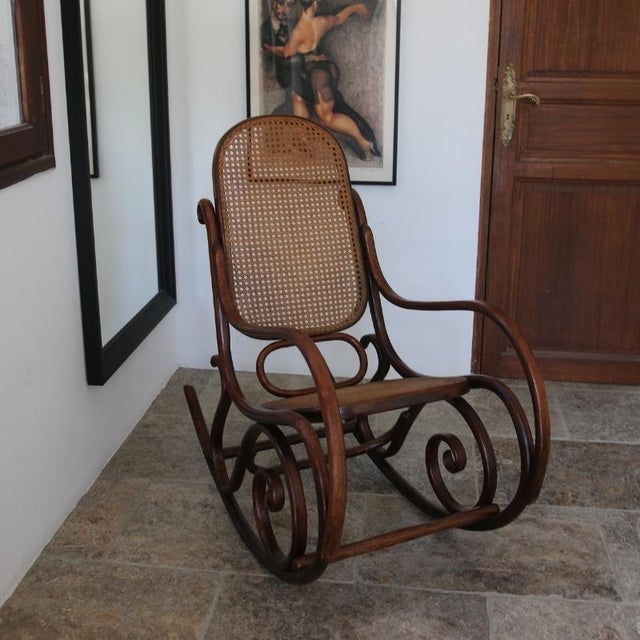 A 1960s-70s bentwood rocking chair, in the style of thonet-inspired furniture. This model incorporates the iconic bentwood...