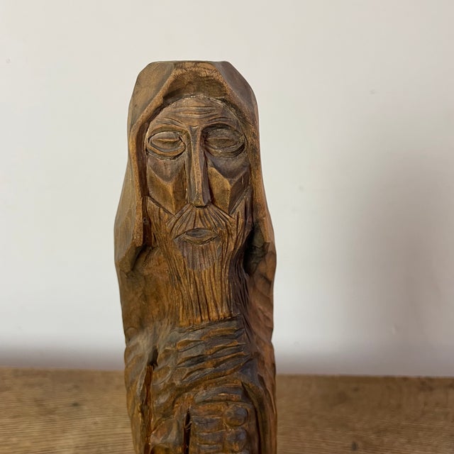 Naïve sculpture of a religious figure in carved wood, folk art. What distinguishes folk art is its deep connection to...