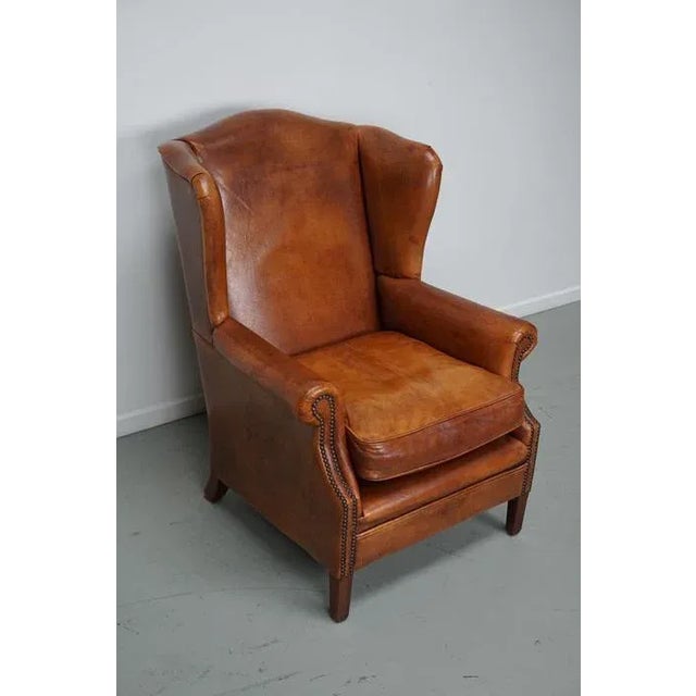 This cognac-colored leather club chair comes from the Netherlands. It is upholstered with cognac-colored leather and...