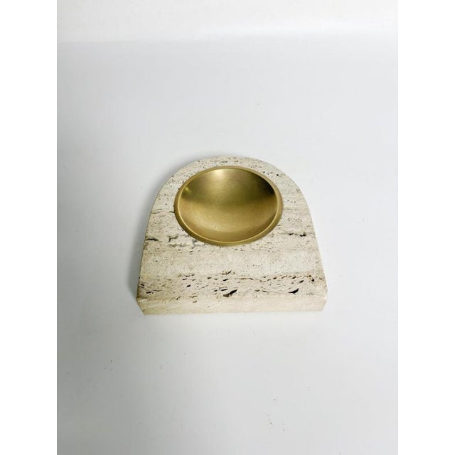 Travertine and brass ashtray, France, 1960s. An elegant modernist ashtray crafted from solid travertine and featuring a...