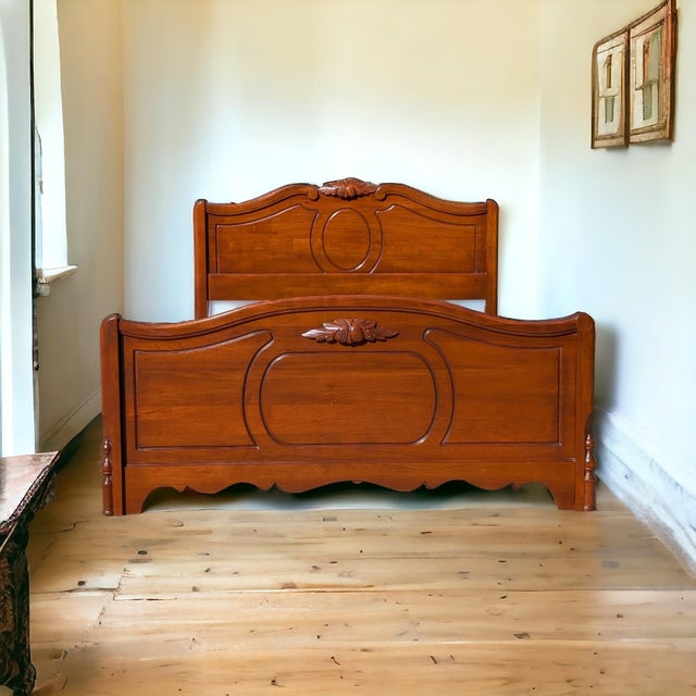 An antique full-size bed frame by Abernathy Furniture, crafted in walnut with a shaped headboard, turned details, and a...