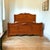 An antique full-size bed frame by Abernathy Furniture, crafted in walnut with a shaped headboard, turned details, and a...