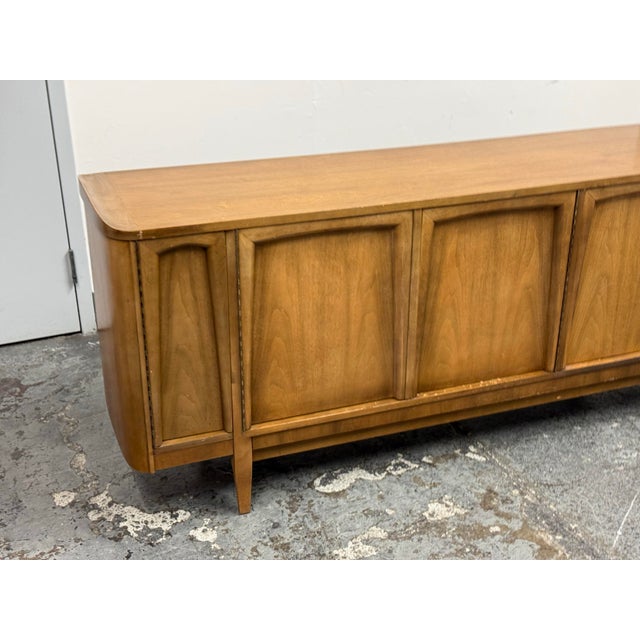 Design Plus Gallery presents an American of Martinsville Mid Century Walnut Sideboard Buffet Credenza. Dating to the...