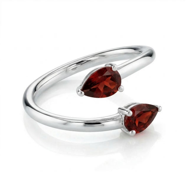 This elegant ring showcases a refined and contemporary design, featuring two vibrant red gemstones gracefully set on a...