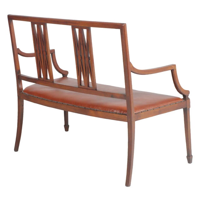 This Art Nouveau settee in solid walnut was reupholstered with leatherette around 1970.