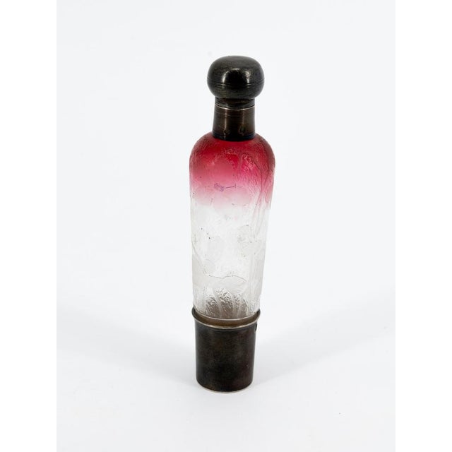 An elegant, slender, cylindrical "travel" perfume bottle, made by the prestigious Daum Manufacture in Nancy around...