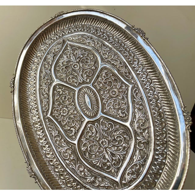 An Anglo Indian or Persian oval tea tray executed in white metal marked/stamped: silver. It is un-magnetic and we have not...