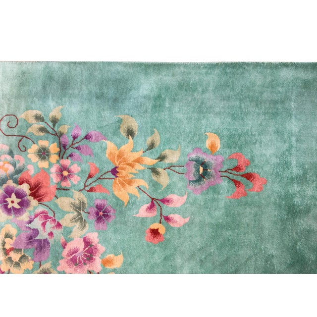 A bold and beautiful early 20th century Chinese Art Deco rug with a mint green field with large auspicious floral clusters...
