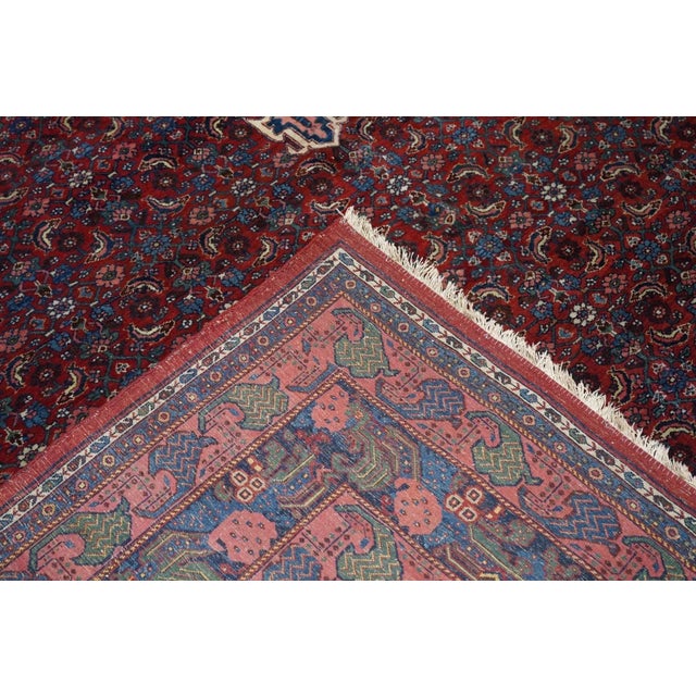This board-like, compactly woven Kurdish scatter shows a red field covered closely with an allover small Herati design. A...