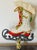 Vintage beaded skating shoe toy mounted on brass base as lamp finial.