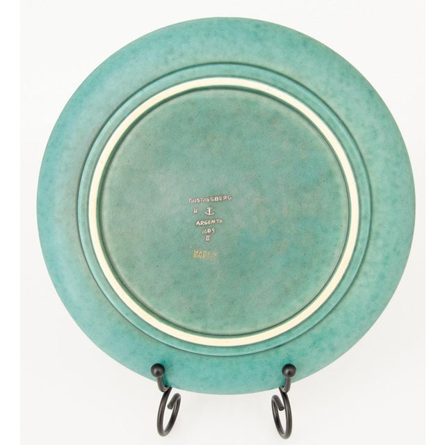 Wilhelm Kåge, plate "Argenta" Gustavsberg, marked Argenta 1609. Decor of a winged griffon in silver against a green...