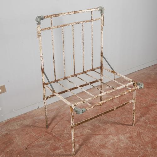 This iron outdoor armchair is an authentic example of vintage garden furniture, featuring a worn, industrial aesthetic...