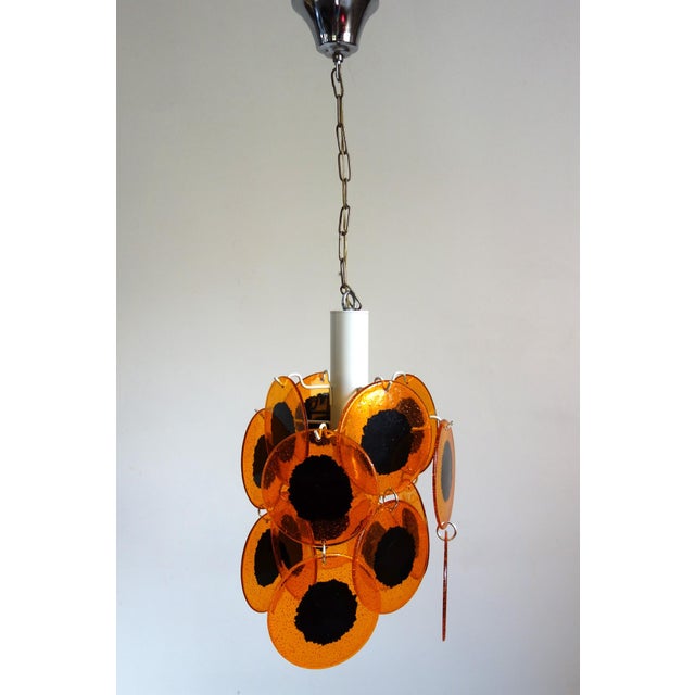 Vintage 1970s space age chandelier inspired by Gino Vistosi. Metal frame. 16 orange/black colored acrylic glass discs...