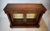 A stately Regency bookcase cabinet with gilt tooled leather top above a single drawer. Two pierced brass lattice trellis...